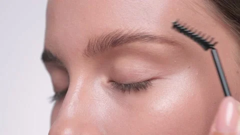 The make-up artist combs the eyebrows. Stock Footage 157957634