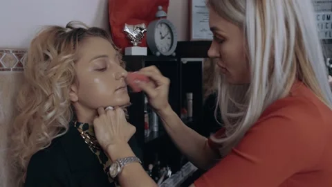 The make-up artist corrects the foundation on the model's face with the sponge Stock Footage 157183260