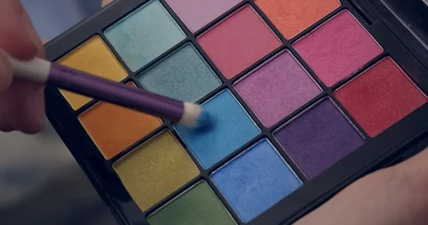 Make-up artist dips a brush in blue palette Stock Footage 126352680
