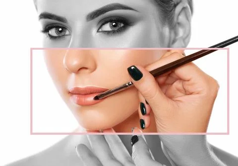 Make-up artist does lips make-up to a woman with smoky eyes makeup. Beautif.. Stock Photos