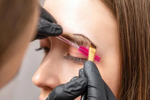 The make-up artist does Long-lasting styling of the eyebrows of the eyebrow.. Stock Photos