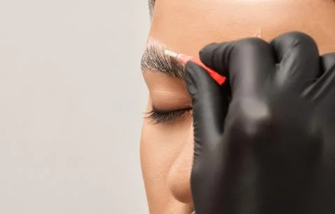 The make-up artist does Long-lasting styling of the eyebrows and will color.. Stock Photos