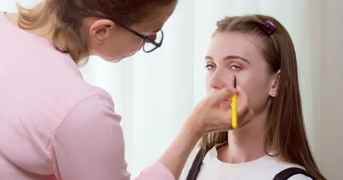 The make-up artist does make-up to the model girl Stock Footage 201368253