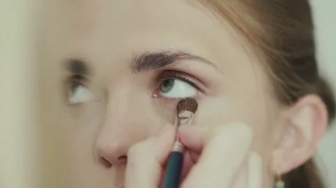Make-up artist does pearlescent shade on the lower eyelid using a brush for make Video stock 68042044