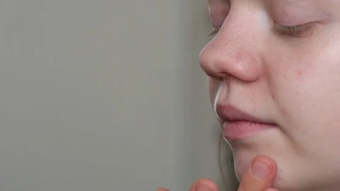 Make-up artist doing make-up of a beautiful young redhead girl, applies cream  Stock Footage 73939184