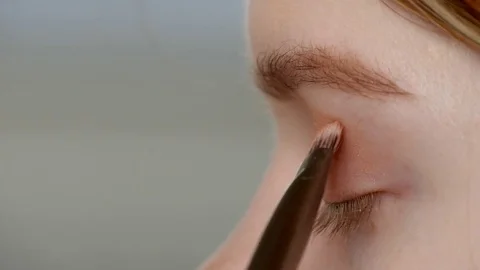 Make-up artist doing make-up of a beautiful young model girl, applies eyeshadow Stock Footage 73939340