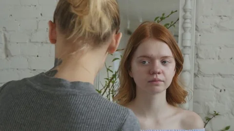 Make-up artist doing make-up of a beautiful young redhead girl, preparing  Stock Footage 73939501