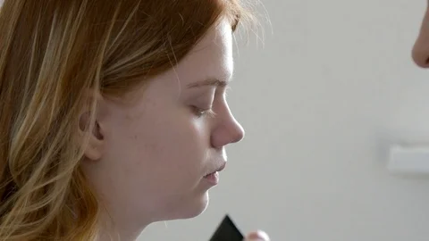 Make-up artist doing make-up of a beautiful young redhead girl, apply concealer  Stock Footage 73939559