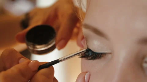 Make-up artist is doing the make-up for charming bride. She is painting the cat Stock Footage