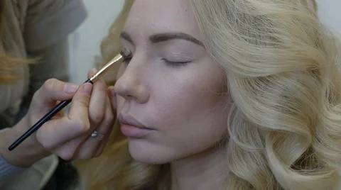 Make-up artist doing make-up model Stock Footage 63131200
