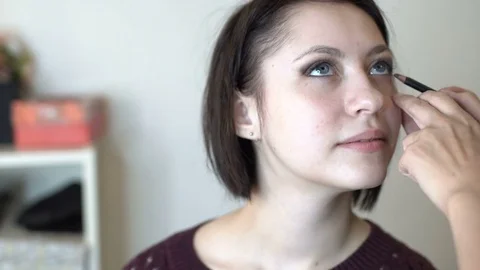 Make-up artist doing makeup and hair styling to a beautiful young woman Stock-Footage 82635802