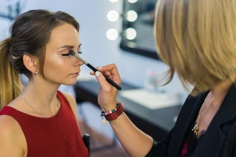 Make-up artist doing makeup to beautiful young girl Foto stock