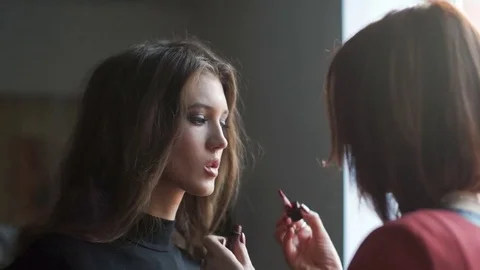 Make up artist doing makeup for model. Lip gloss application Stock Footage 74124889