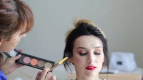 Make up artist doing professional make up of young woman Stock Footage 82037433
