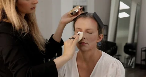 Make up artist doing professional make up of young woman. Stock Footage 304628212
