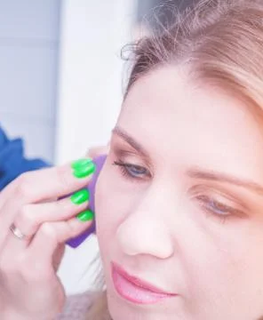 Make up artist doing professional make up of young woman with stylish blonde Stock Photos