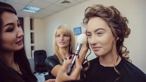 Make up artist doing professional makeup and hair stylist makes hairstyle of Stock Footage 68951292