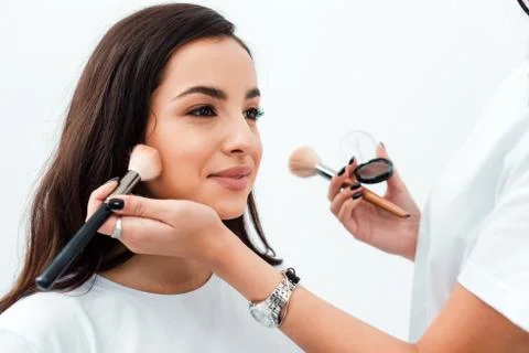 Make up artist doing professional makeup of young woman in beauty studio Stock Photos