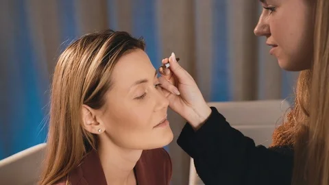 Make-up artist draws and induces the shape of the eyebrows with a pencil on the Stock Footage 101097989