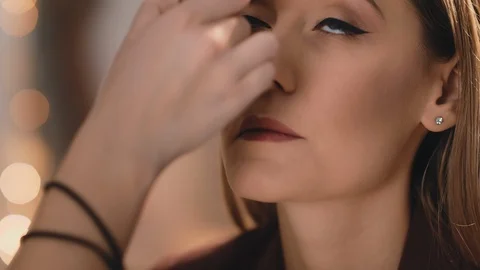 Make-up artist finishes makeup by applying powder with a professional brush on Stock Footage 101235428