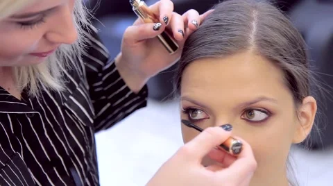 Make-up artist highlight model's eyes with mascara Stock Footage 68746996