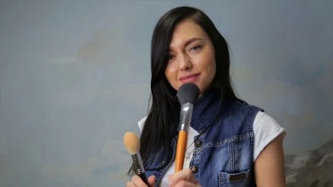 The make-up artist holds in hands a brush for a make-up Stock Footage 85322012