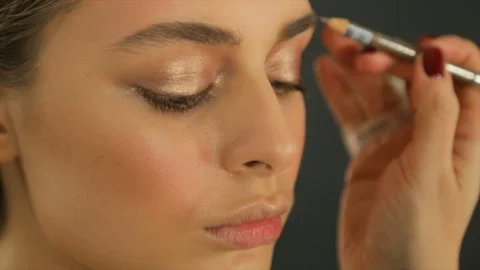 Make-up artist makes eyebrow correction for a girl Stock Footage 86331410