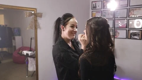 Make-up artist makes make-up an attractive model Stock Footage 84989349