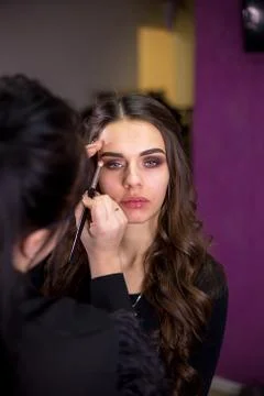 Make-up artist makes make-up an attractive model Stock Photos