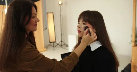 A make-up artist makes a make-up for a beautiful brunette model. Video stock 279913599