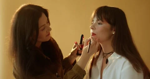 A make-up artist makes a make-up for a beautiful brunette model. Stock Footage 279916103