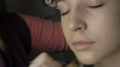 Make-up artist makes makeup to a young girl Stock Footage 102042506