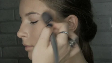 Make-up artist makes makeup to a young girl Stock Footage 102379634