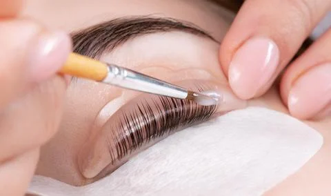 Make-up artist makes the procedure of lamination and dyeing of eyelashes to.. Stock Photos
