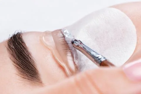 Make-up artist makes the procedure of lamination and dyeing of eyelashes to.. Stock Photos