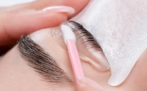 Make-up artist makes the procedure of lamination and dyeing of eyelashes to.. Stock Photos