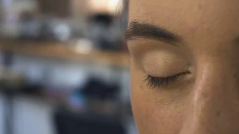 Make-up artist makes a professional make-up for a beautiful girl Stock Footage 77552075
