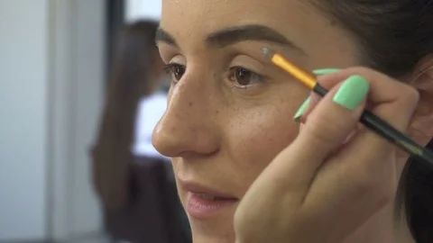 Make-up artist makes a professional make-up for a beautiful girl Vídeos de archivo 77553300
