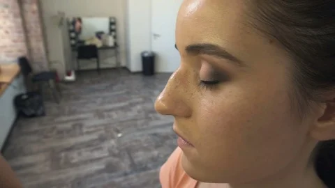 Make-up artist makes a professional make-up for a beautiful girl Video stock 77553585