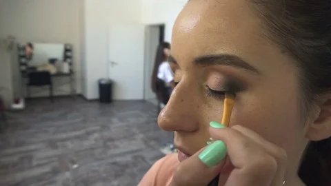 Make-up artist makes a professional make-up for a beautiful girl Video stock 77553685