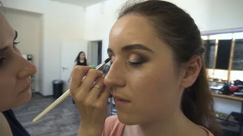 Make-up artist makes a professional make-up for a beautiful girl 動画素材 77553780