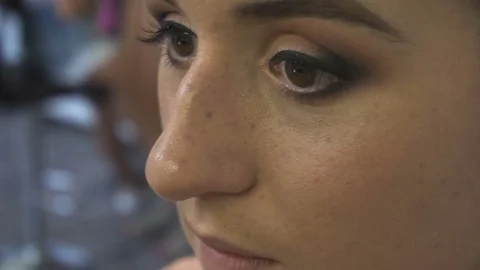 Make-up artist makes a professional make-up for a beautiful girl Stock Footage 77555381