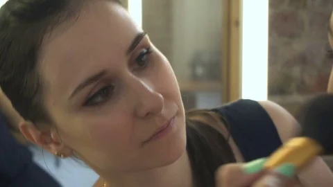 Make-up artist makes a professional make-up for a beautiful girl Vídeos de archivo 77555844