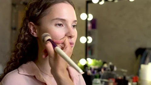 Make-up artist makes sculpting on the face of a beautiful model beauty salon Stock Footage 131198791