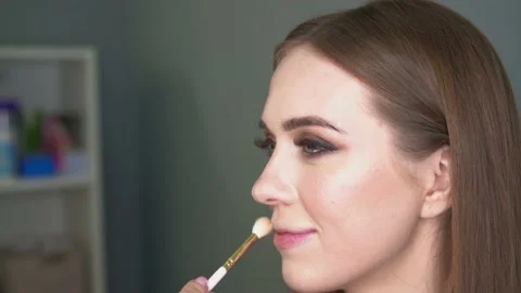 Make-up artist making face correction by brush. Shining eyes, glitters. Stock Footage 154964452