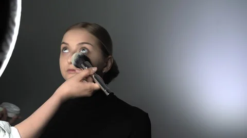 Make-up artist making professional make-up for young woman in beauty studio Stock Footage 128184195