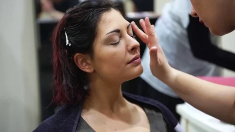 Make up artist making up a young beautiful woman, 4k Stock Footage 74605493