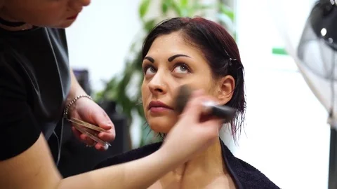 Make up artist making up a young beautiful woman, 4k Video stock 76558320