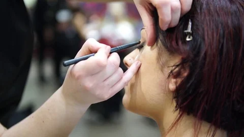 Make up artist making up a young beautiful woman, 4k Stock Footage 77898405