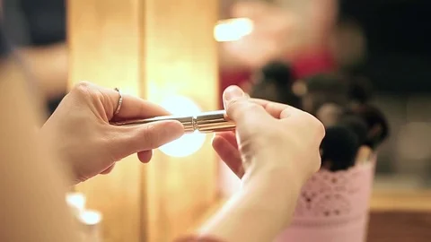 Make up artist opens mascara close up in slow motion Stock Footage